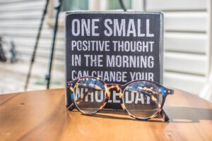 Photo of a Sign and Eyeglasses on Table
