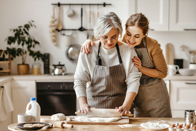 A caregiver is cooking with someone with dementia.