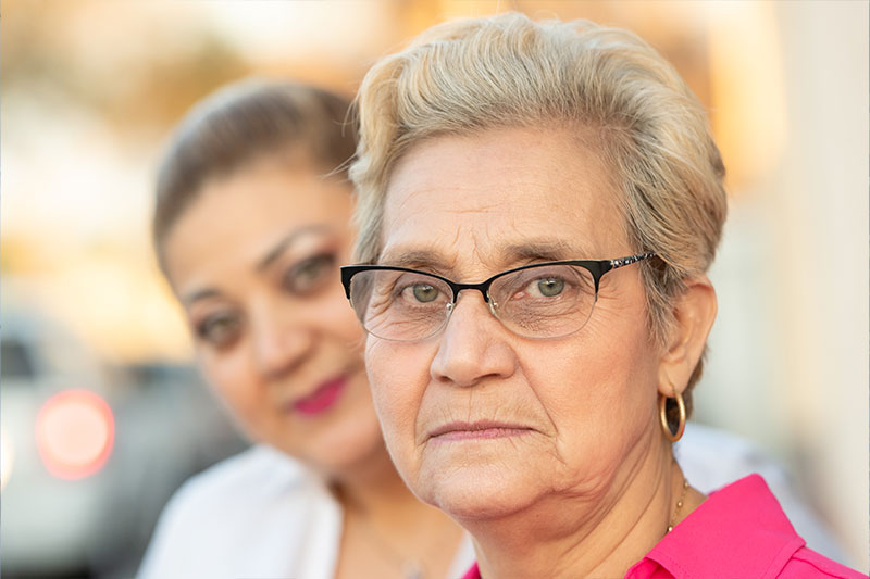 An older woman and her daughter look at the camera as they ponder what family caregivers say they need.