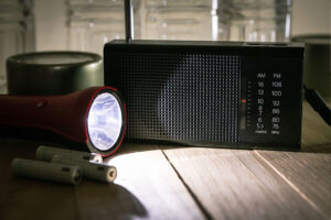 A flashlight and battery-powered radio symbolize some of the ways you can help seniors prepare for power outages.