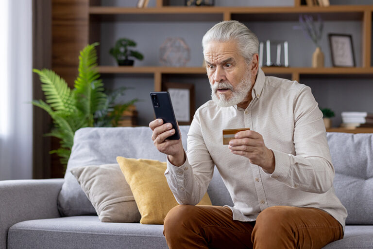 A man who has is building his senior scam awareness notices something fishy on his phone.