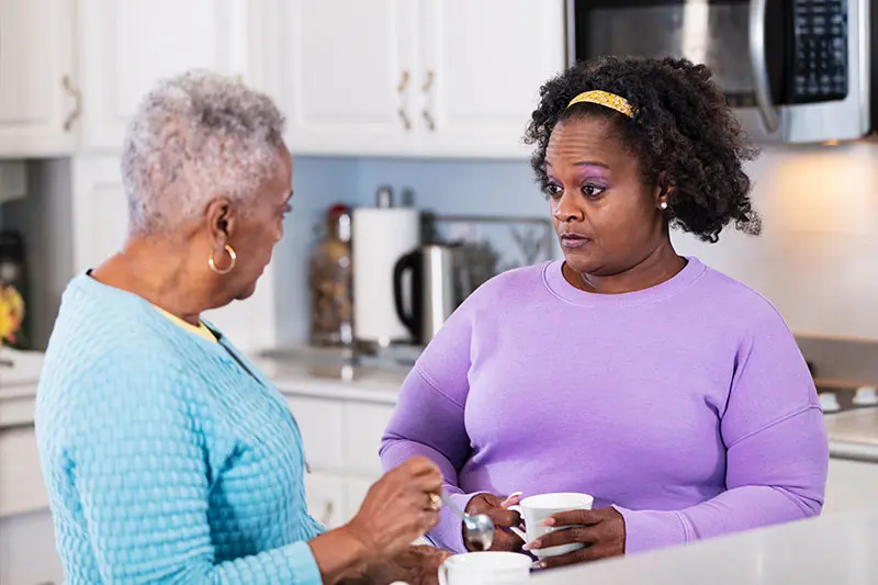 An adult daughter has dementia care conversations with her aging parent at home.