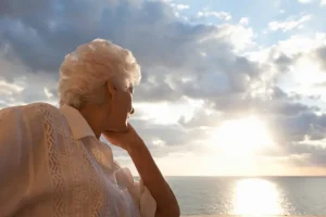 A woman experiencing senior grief in older adults stares out at the water.